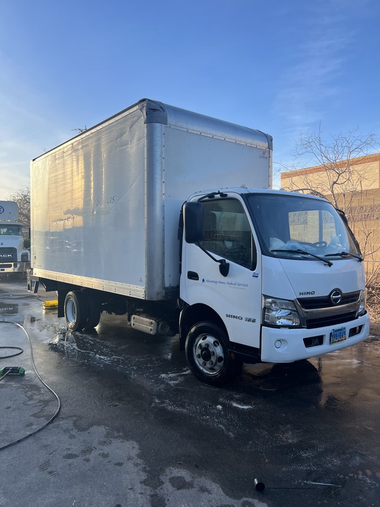 Hino box truck being pressure washed on-site