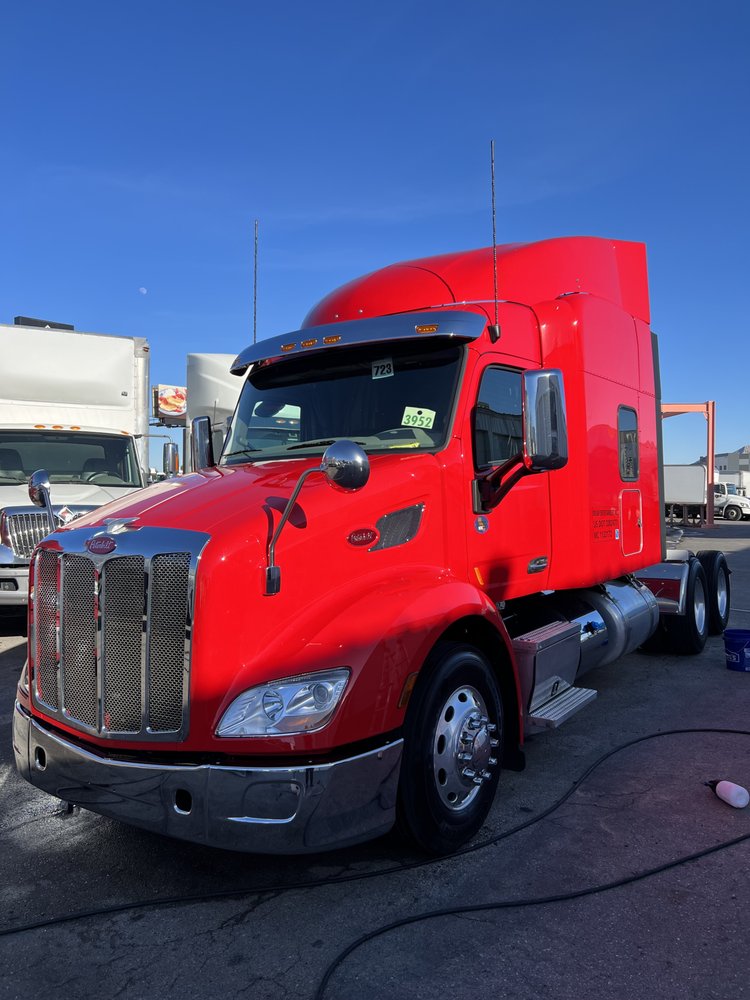 Freshly washed red Peterbilt semi-truck fleet washing
